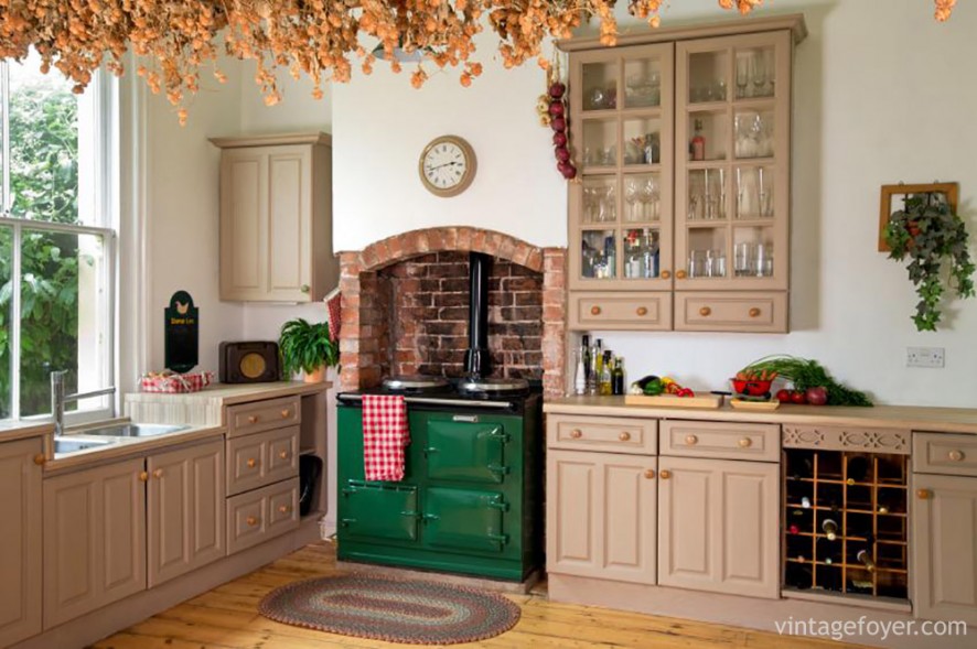 If you’re looking for a cozy cottage feel for your kitchen, try including red brick. The pink hues of the cabinets are a beautiful contrast to the brick and bright green vintage stove.