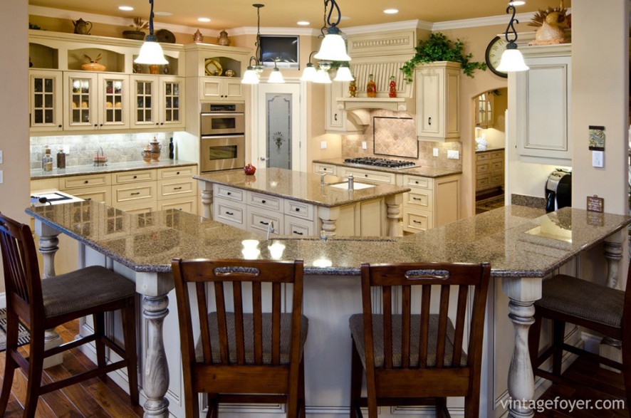 This traditional yet welcoming kitchen is perfect for a large number of guests. With its large wrap-around counter top and island, its cottage-style glass cabinets and red-stained bar chairs, this kitchen is open but warm and colorful. 