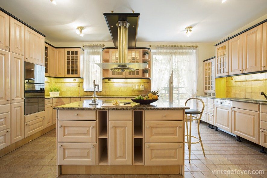 Warm and honey colored, this kitchen is alive with natural light and floor-to-ceiling cabinet space. The dark marble counter tops provide a nice, natural contrast to the cream-colored floors and cabinets.