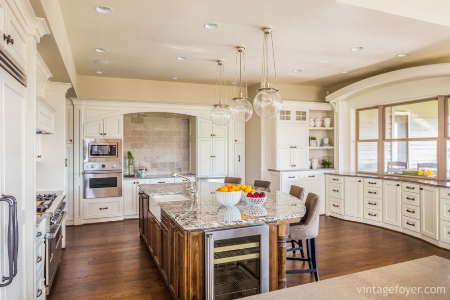 The perfect combination of kitchen and dining room: the large, oval shaped island is perfect for cooking and dining, surrounded by beautiful cream colored cabinets. 