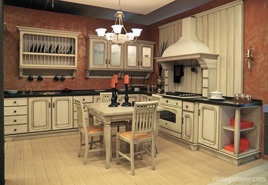 This kitchen beautifully contrasts the warm pink of the walls with the cream-colored cabinets and matching hardwood flooring.