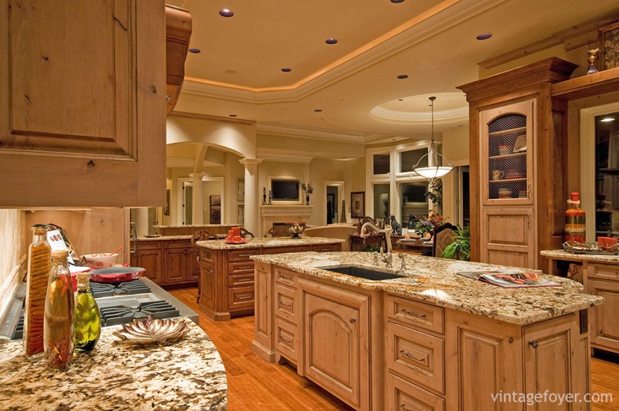 A vibrant mixture of wood and marble bring this kitchen to life. The intricate design of the countertop coupled with the soft lighting creates an atmosphere of luxury and sophistication. 