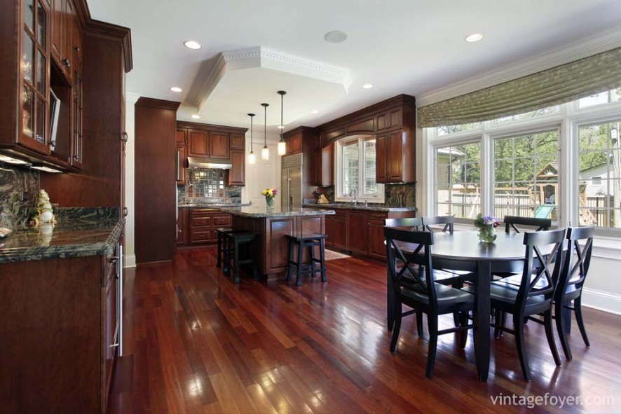 Dark cherry hardwood flooring and custom traditional cabinetry, and black and grey marble countertops throughout. 