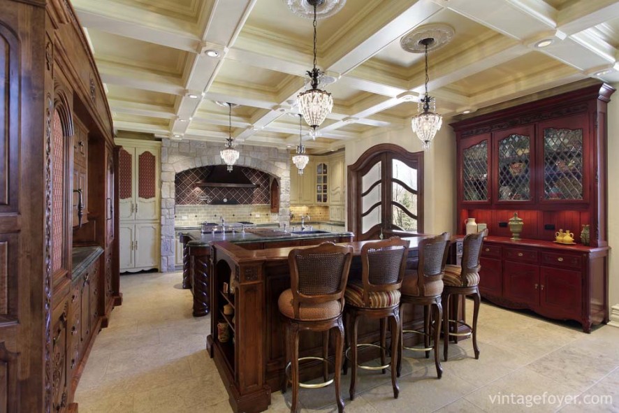 Custom stone arch inset for oven, dark toned custom antique cabinetry, and light toned porcelain tile flooring. 