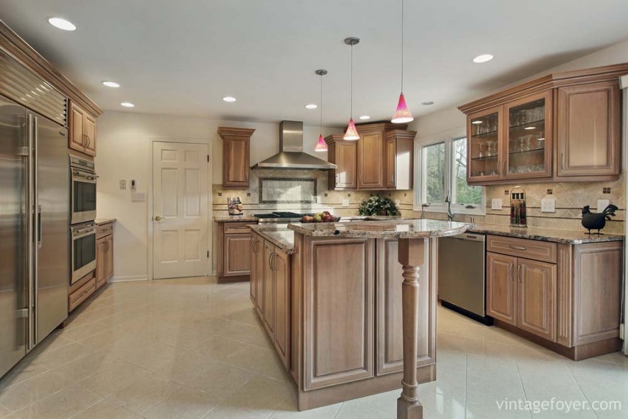 High end stainless steel appliances, light toned traditional style cabinetry, and beautiful tan marble countertops.