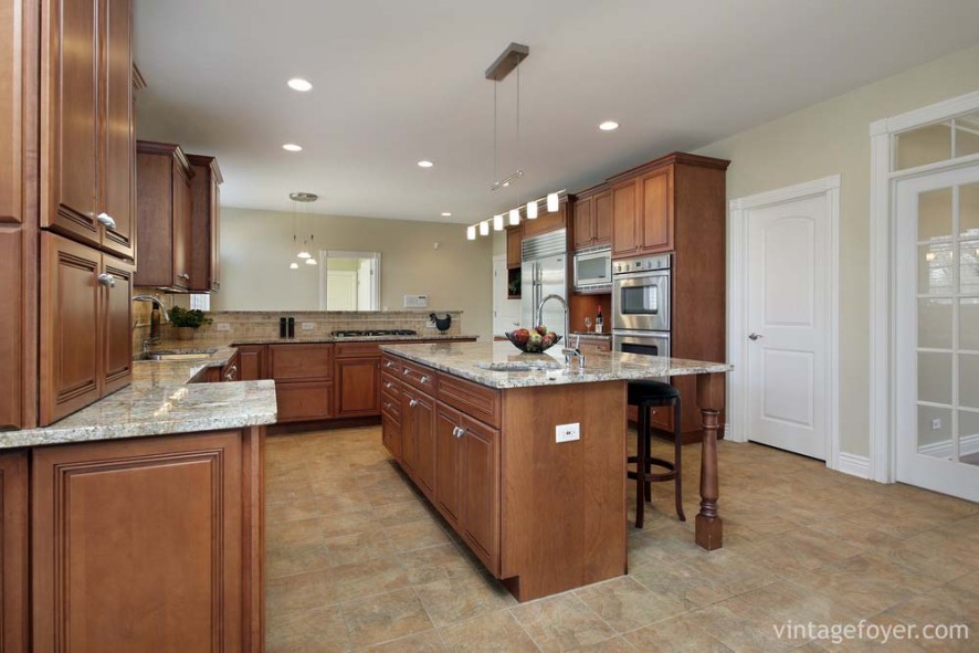 Stainless steel appliances, light tan marble countertops, beautiful multi-toned porcelain tile, and custom cabinetry. 