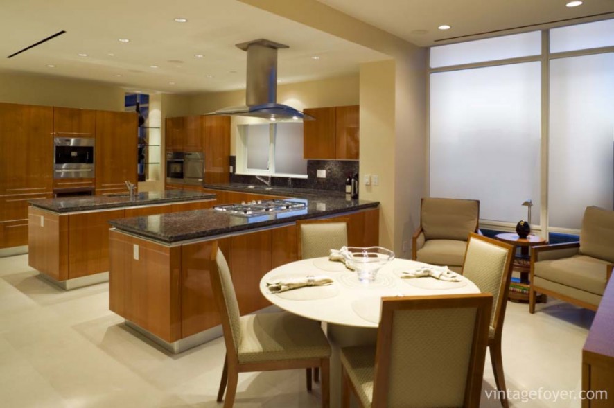 Smooth cream toned flooring, medium toned hardwood cabinetry with sleek modern appeal, and a beautiful black marble countertop. 